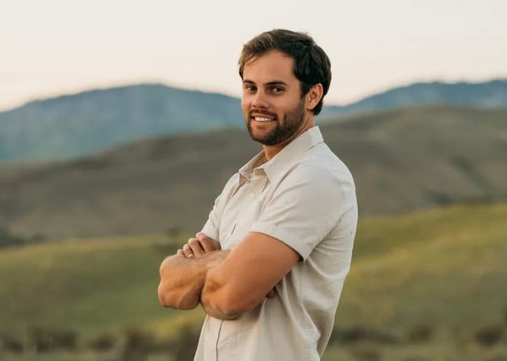 Portrait of a member of Rainier Construction, outdoors with foothills behind him