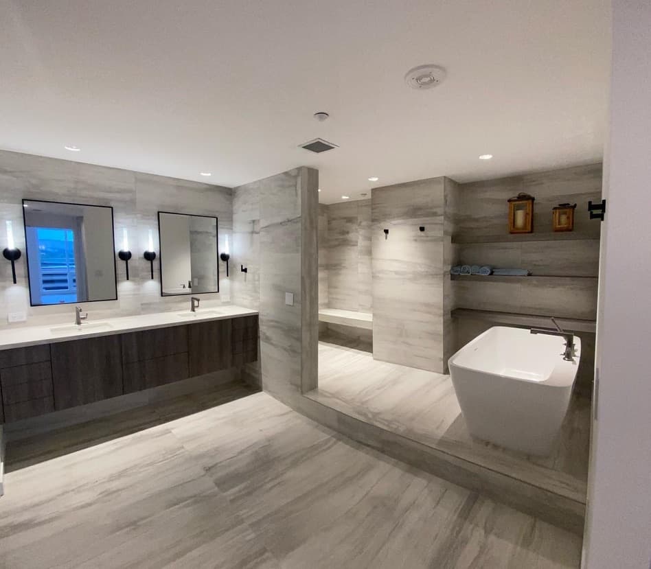 Primary bath with a freestanding tub, tiled shower, and floating vanity, from Rainier Construction project photography