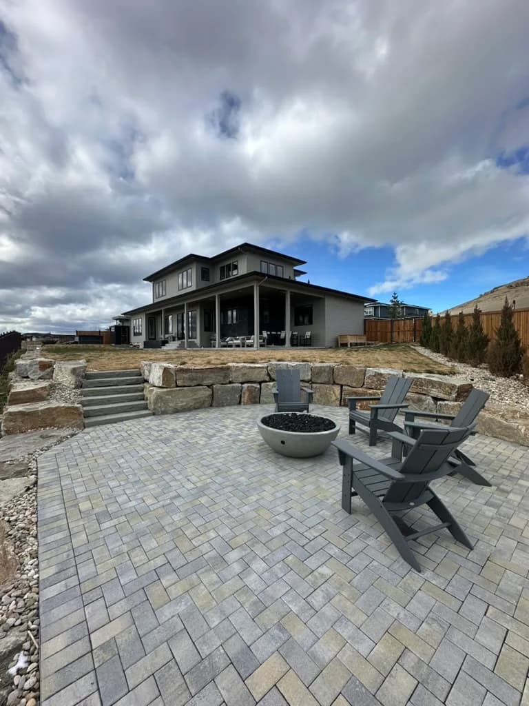 Custom residence with a patio, stone retaining walls, and an outdoor living area