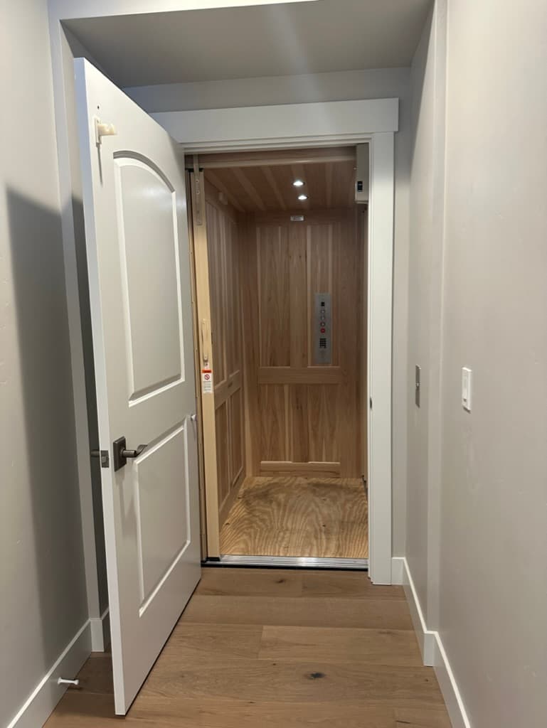 Residential elevator with a light wood interior