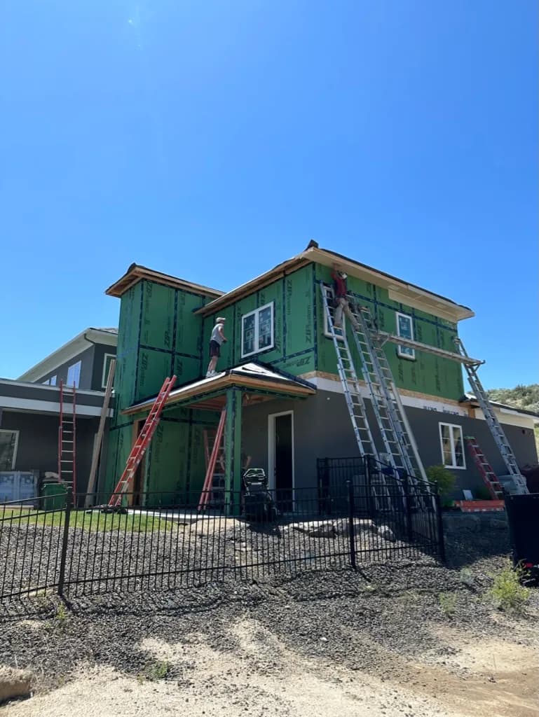 Residence exterior during construction, with sheathing and trim in progress
