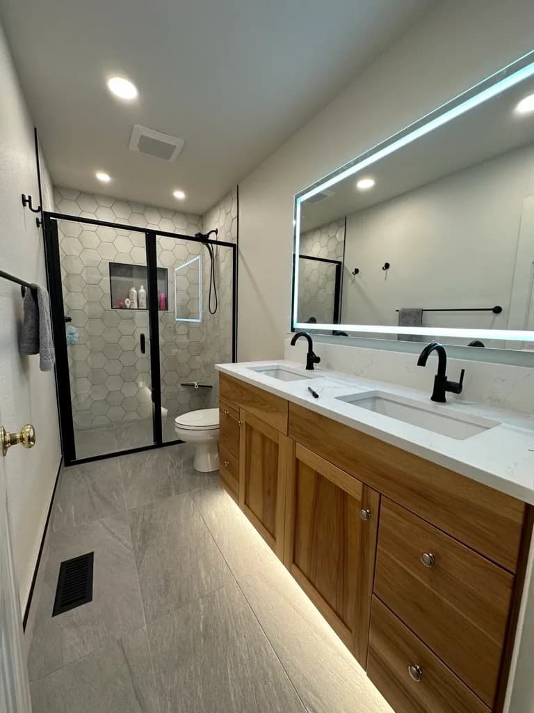 Bath with a light wood floating vanity and a tiled walk-in shower