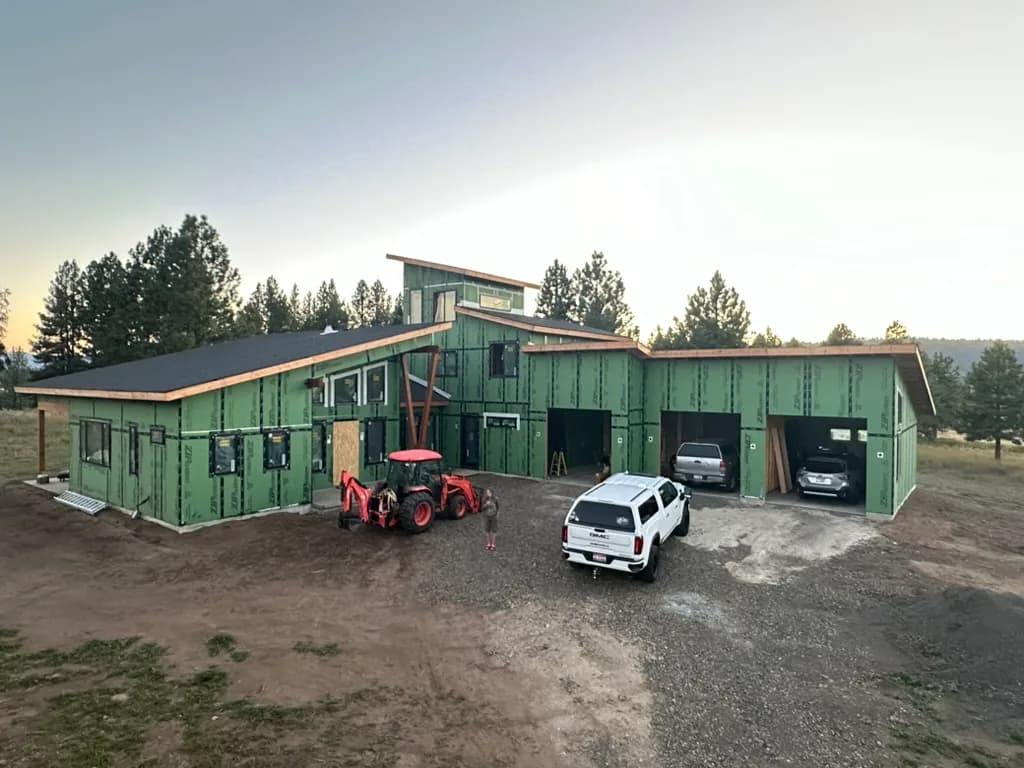 Multi-level residence in weather barrier with a timber entry and an attached garage