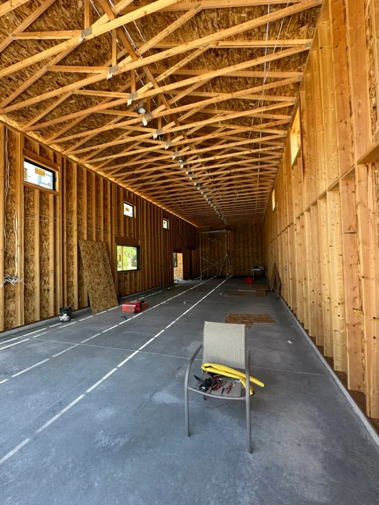 Interior framing of a large open building with roof trusses